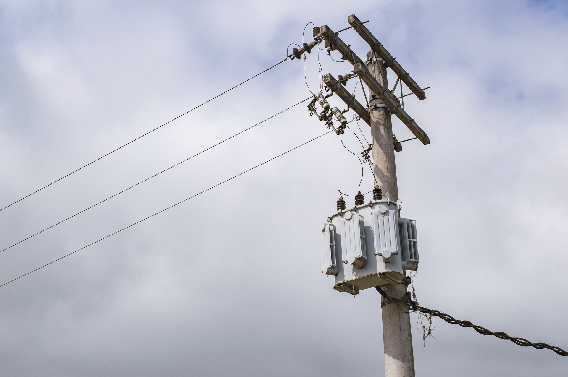 Low-angle shot of a power line on an electric post against a cloudy sky in São Paulo, Brazil.